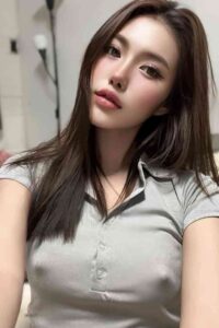 Portrait of a young woman with long brown hair, wearing a light gray collared shirt.